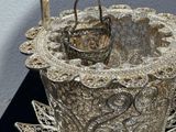 a silver basket that is sitting on a black table