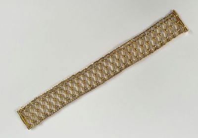 gros plan d'un bracelet en chaîne en or sur une surface blanche