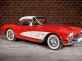 an old red and white car parked in front of a brick wall