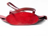 a red purse that is sitting on a white surface