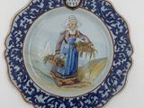 une assiette bleue et blanche avec une image de femme dessus