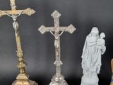 three figurines of jesus and a crucif on a black background