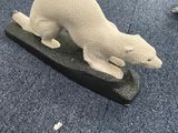 sculpture représentant un ours polaire assis sur un bloc de bois