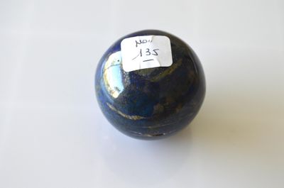 une balle bleue avec un autocollant dessus, posée sur une table