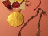 une table rose sur laquelle sont posés un collier, un bracelet et une bague