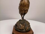a bronze statue of a rooster on top of a plaque