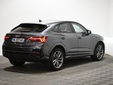 the rear end of a grey audi qx parked on a checkered floor