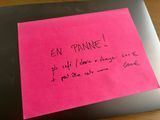pink post it note with french writing on a laptop computer