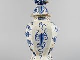 blue and white vase with a bird on top of it