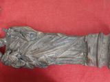 une statue représentant une femme tenant un enfant dans ses bras, posée sur un socle rouge