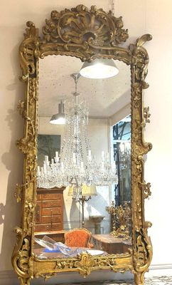 a large gold mirror sitting on a table in a room