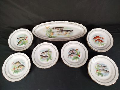 six assiettes sur lesquelles sont peints des poissons sur fond noir