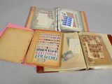 three open books sitting on a table with stamps on them