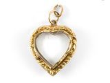 a close up of a gold heart pendant on a white background