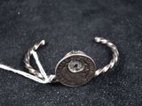 une photo d'un bracelet en argent surmonté d'une pièce