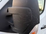a side view mirror of a white van with a broken mirror