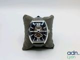 a watch that is sitting on a pillow on a white surface