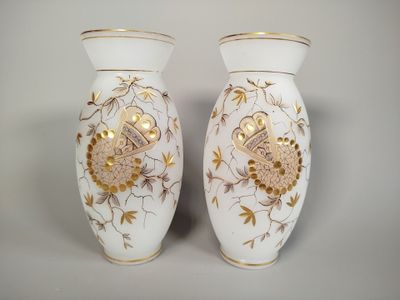 two white vases with gold designs on them