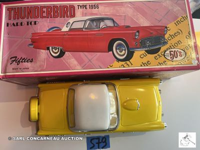 une petite voiture rouge et jaune posée sur une boîte