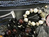 many different types of jewelry on a black table