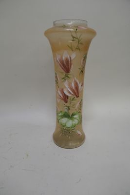 un vase avec des fleurs peintes dessus, posé sur une table
