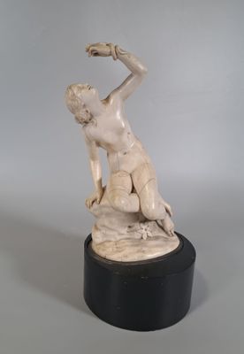 statue d'une femme assise sur un rocher, tenant un oiseau dans la main