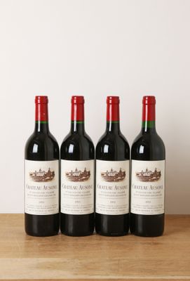 trois bouteilles de vin rouge sont alignées sur une table en bois
