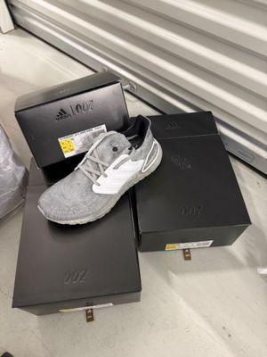 une paire de baskets blanches et noires posée sur une boîte noire