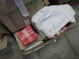 a cardboard box filled with clothes and a blanket