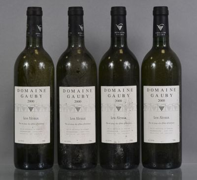 four bottles of wine are lined up on a table