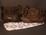 two brown purses sitting next to each other on top of a table