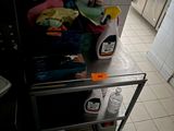a metal cart with cleaning products on it in a kitchen