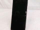 a black cell phone sitting on a stand on a table