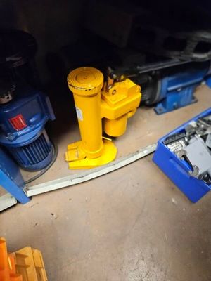 une borne d'incendie jaune posée par terre à côté d'une boîte bleue