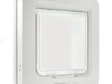 un gros plan sur une chatière blanche posée sur un mur blanc