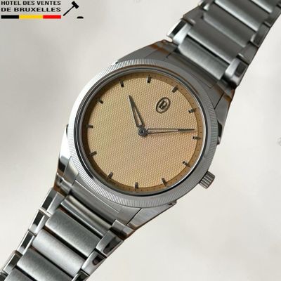 a close up of a wrist watch on a white surface