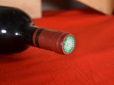 a bottle of wine sitting on a red table cloth