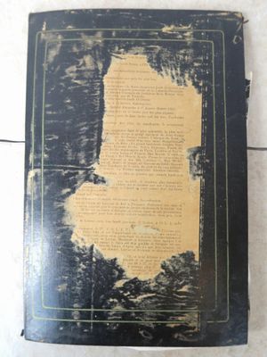 un vieux livre posé sur un sol carrelé, près d'un mur