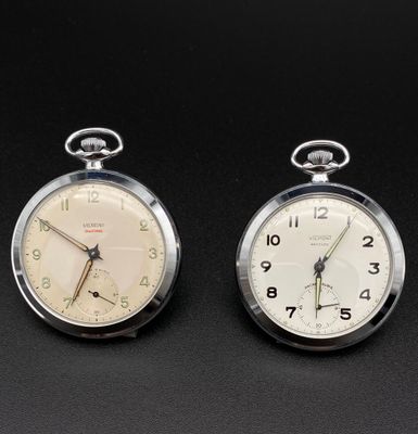 deux horloges posées côte à côte sur une surface noire