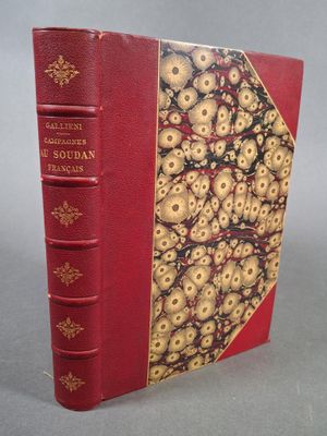 un vieux livre à la couverture rouge ornée de motifs dorés