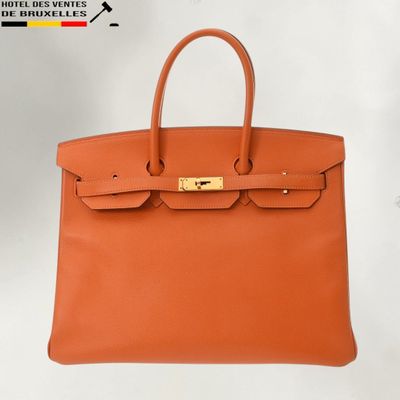 a brown leather handbag with gold hardware on the handle