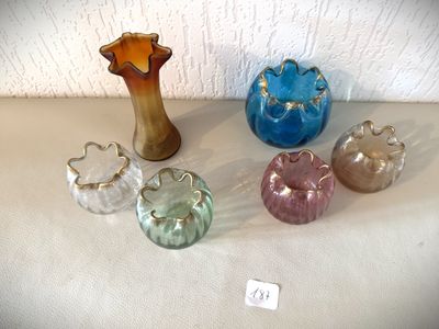 cinq vases en verre de couleurs différentes posés sur une table