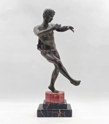 statue en bronze représentant un homme tenant une raquette de tennis, posée sur un socle en marbre