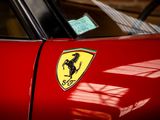 ferrari badge on a red sports car parked in a garage