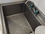 a sink in the corner of a kitchen with a bowl on the counter
