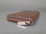 a small brown purse with a zipper on a table
