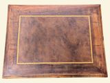 a close up of a wooden table with a brown leather surface
