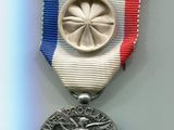 médaille d'argent avec un ruban rouge, blanc et bleu sur fond blanc