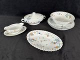four pieces of porcelain dishes and cups on a black surface