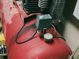 a red air compressor sitting on top of a red tank